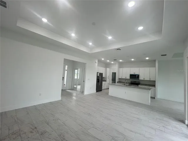 a view of a kitchen with kitchen island a sink wooden floor and a counter top space
