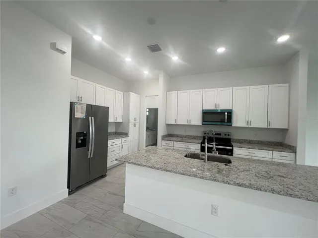 a kitchen with stainless steel appliances a refrigerator and a stove top oven