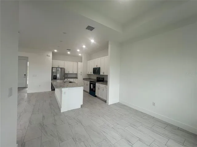 a view of kitchen with refrigerator sink and stove