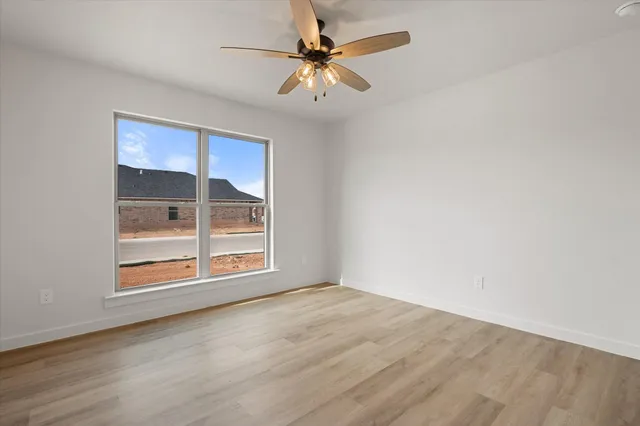 an empty room with fan and windows