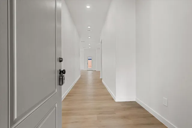 a view of a hallway with wooden floor