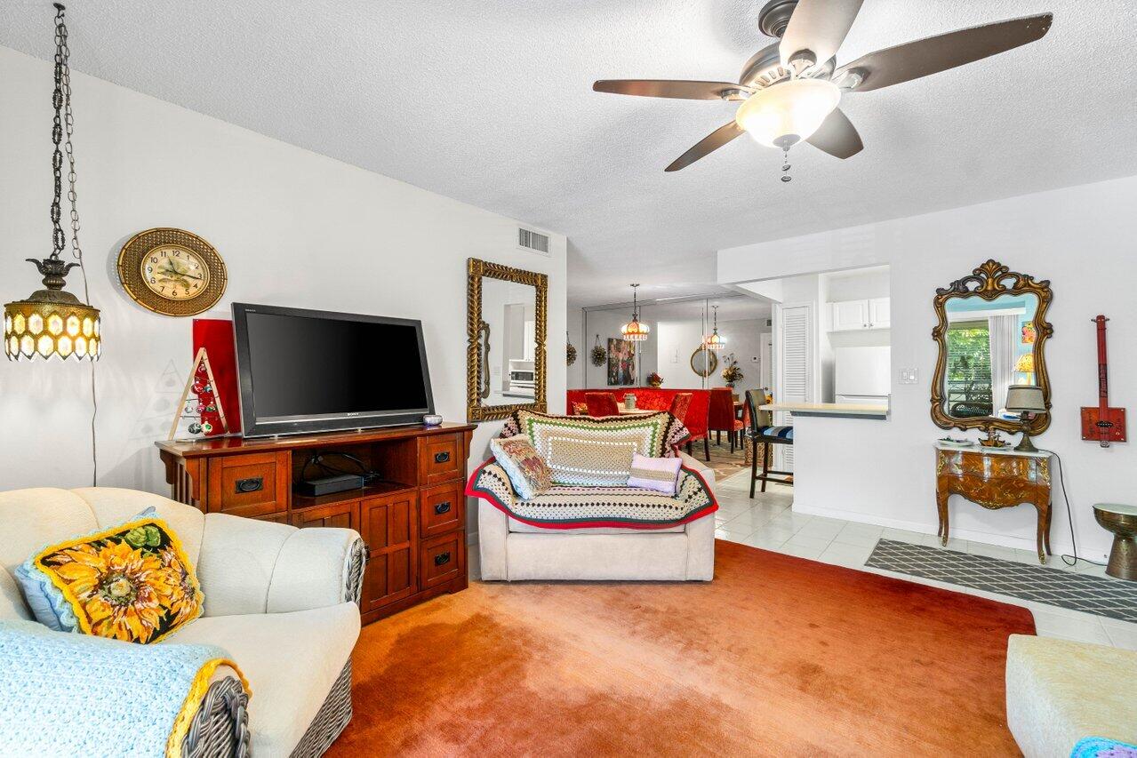 1124 Northwest 13th Street, Unit 204A Boca Raton, FL 33486 - Photo 11 of 30 a living room with furniture and flat screen tv