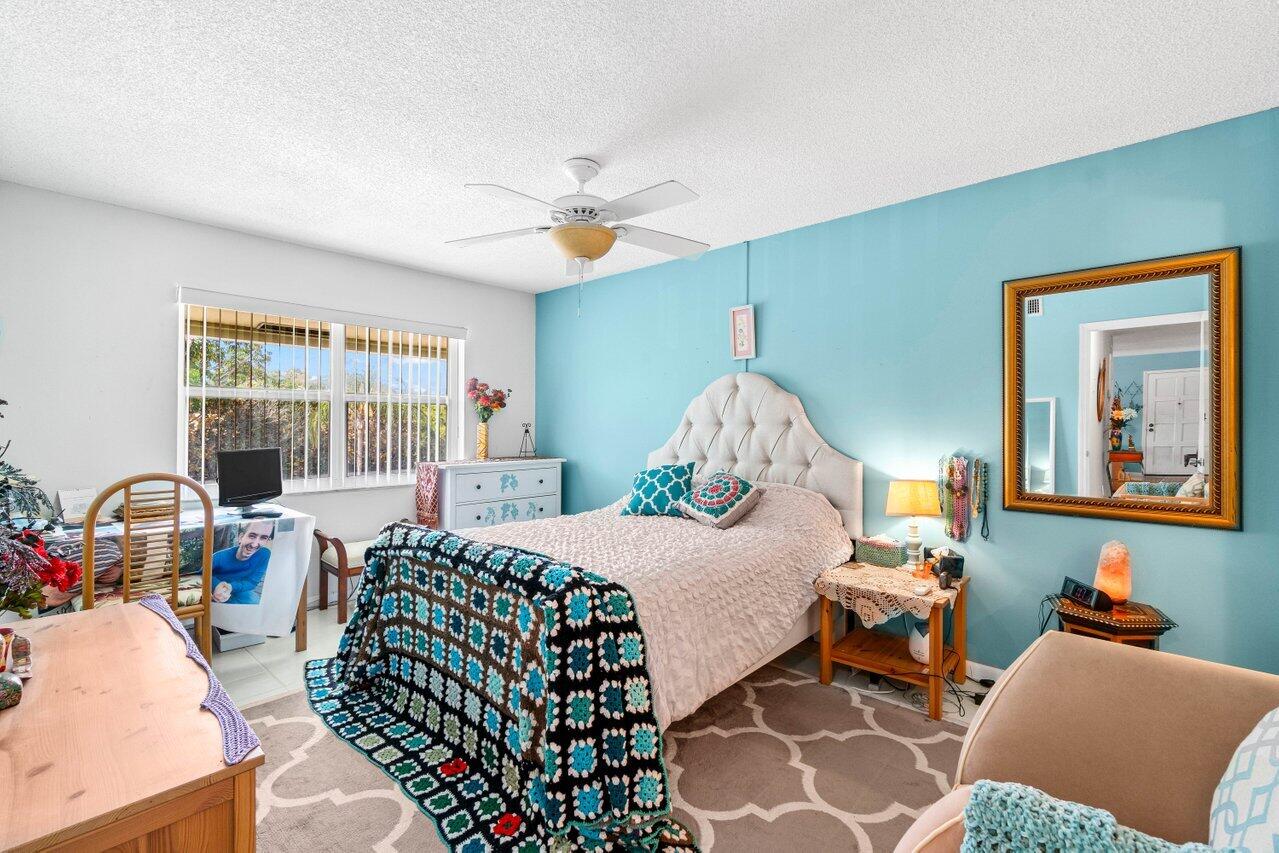 1124 Northwest 13th Street, Unit 204A Boca Raton, FL 33486 - Photo 12 of 30 a bedroom with a bed couch and a window