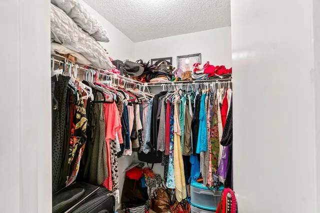a view of walk in closet with clothes