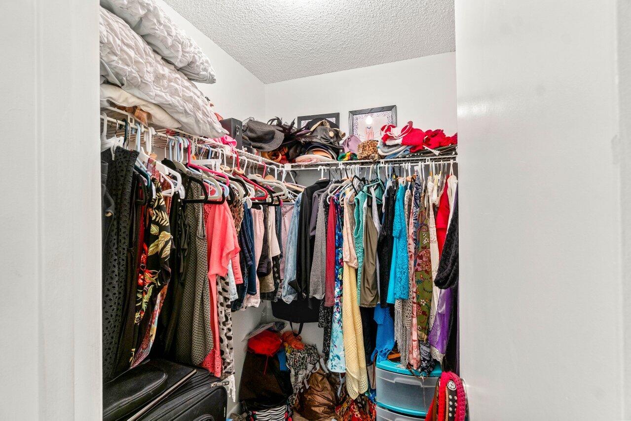 1124 Northwest 13th Street, Unit 204A Boca Raton, FL 33486 - Photo 13 of 30 a view of walk in closet with clothes