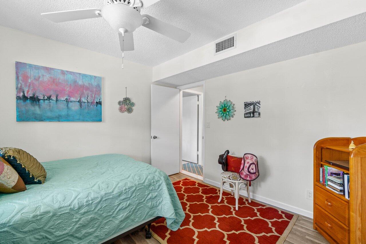 1124 Northwest 13th Street, Unit 204A Boca Raton, FL 33486 - Photo 16 of 30 a bedroom with a bed and a painting on the wall