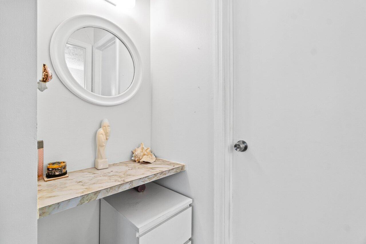 1124 Northwest 13th Street, Unit 204A Boca Raton, FL 33486 - Photo 19 of 30 a bathroom with a sink and a mirror