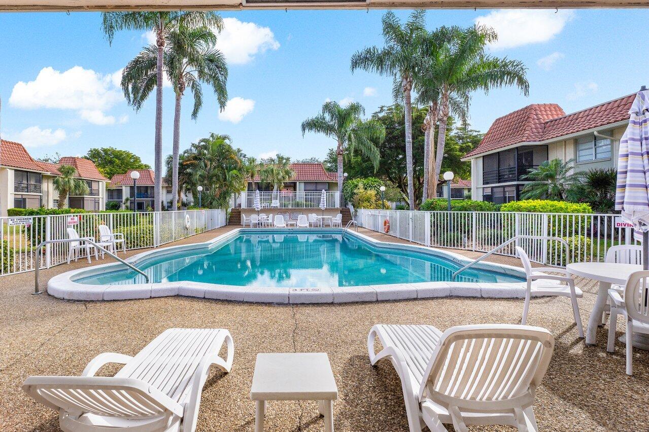1124 Northwest 13th Street, Unit 204A Boca Raton, FL 33486 - Photo 25 of 30 a view of swimming pool with a lounge chairs