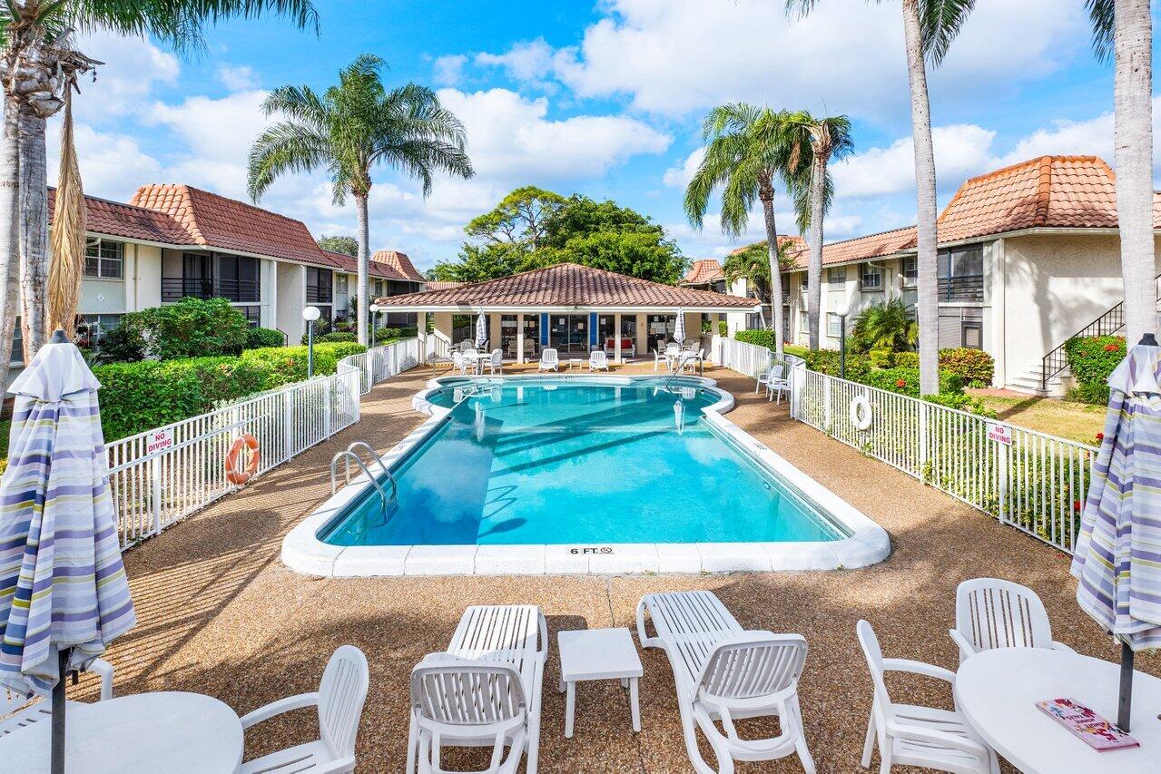1124 Northwest 13th Street, Unit 204A Boca Raton, FL 33486 - Photo 28 of 30 a front view of a house with a yard table and chairs