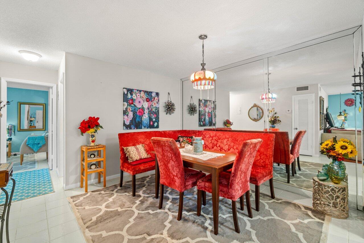1124 Northwest 13th Street, Unit 204A Boca Raton, FL 33486 - Photo 5 of 30 a view of a dining room with furniture and chandelier