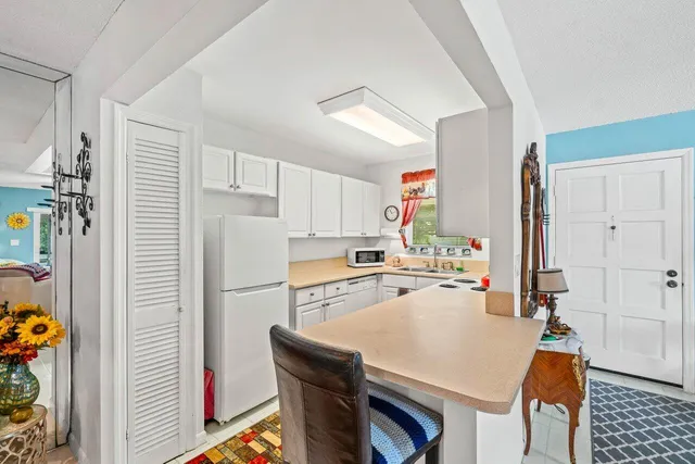 a kitchen with a refrigerator a stove and a dining table with wooden floor