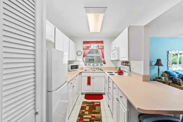 a very nice looking open kitchen with a stove a sink and a refrigerator