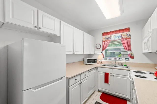 a kitchen with white cabinets and white appliances