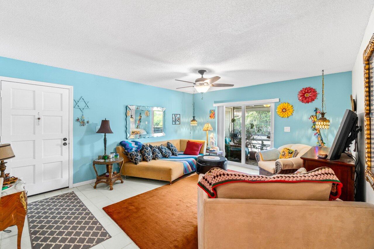 1124 Northwest 13th Street, Unit 204A Boca Raton, FL 33486 - Photo 9 of 30 a living room with furniture and a rug