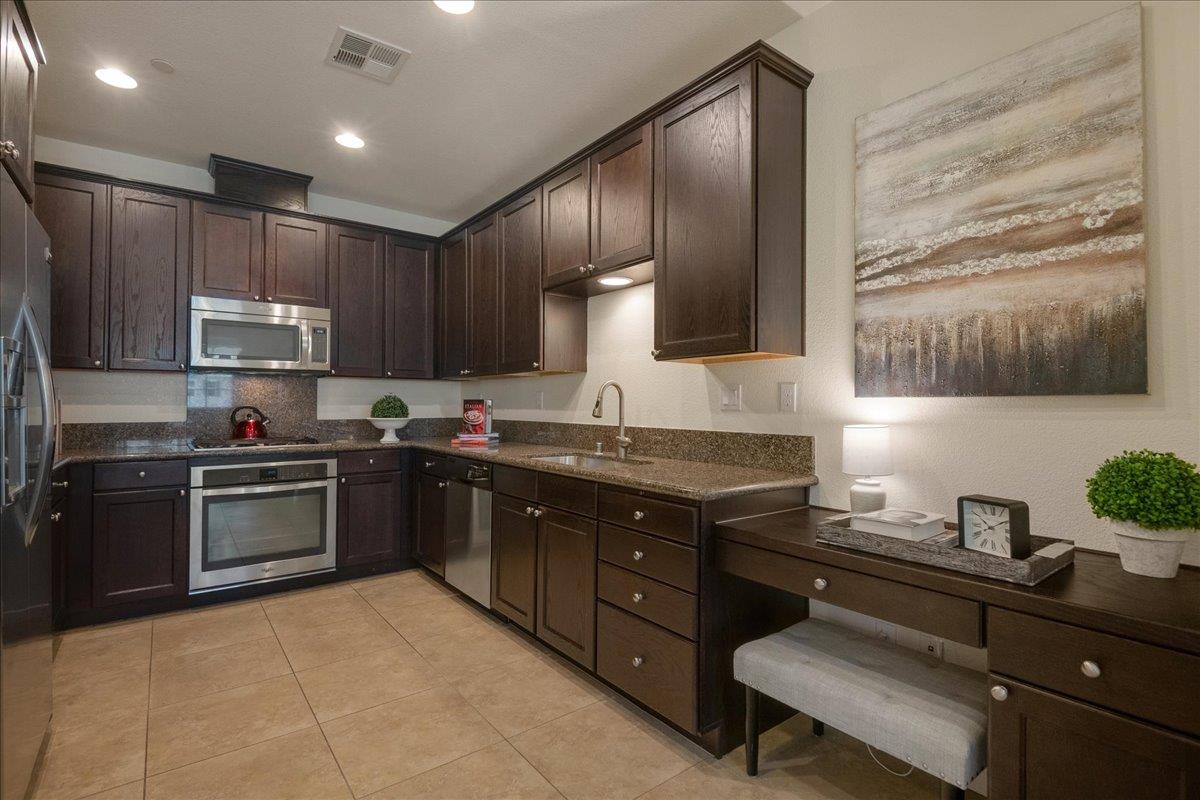 635 True Wind Way, Unit 515 Redwood City, CA 94063 - Photo 17 of 46 a kitchen with a sink stove and wooden cabinets