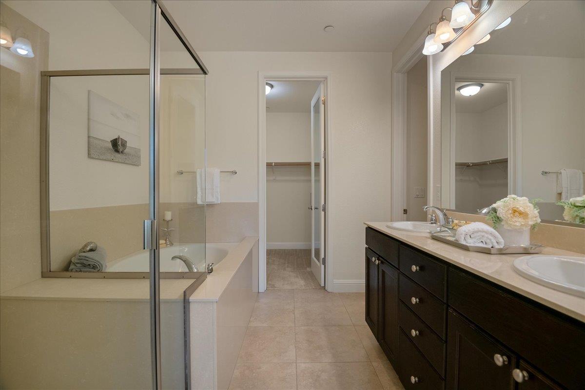 635 True Wind Way, Unit 515 Redwood City, CA 94063 - Photo 31 of 46 a bathroom with a granite countertop sink a shower and a mirror