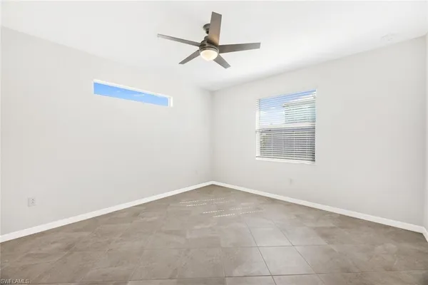 an empty room with a ceiling fan and window
