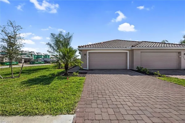 a front view of a house with a yard and a garage