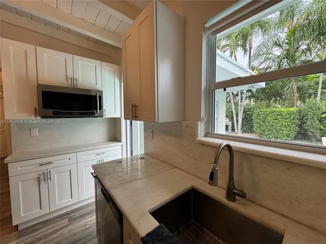 a kitchen with stainless steel appliances a sink a stove a microwave and cabinets