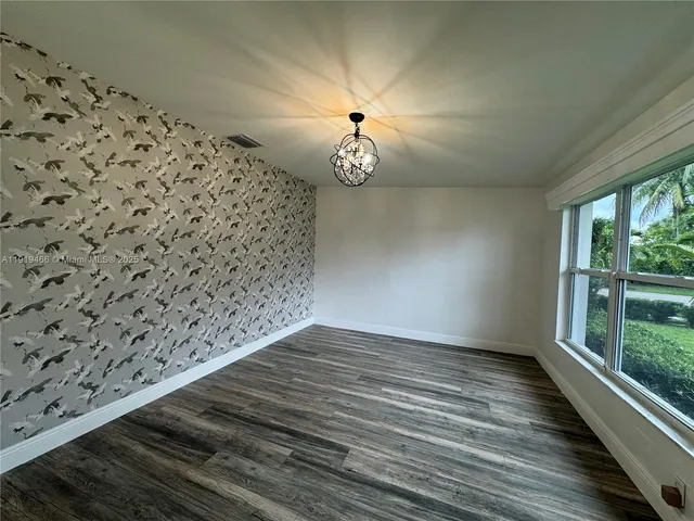 en empty room with wooden floor and fan