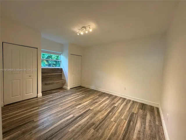 a view of an empty room with a fireplace and a window