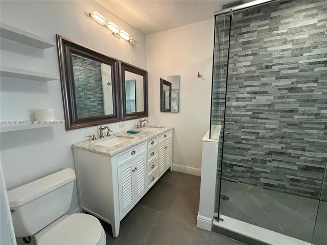a bathroom with a granite countertop sink toilet and shower
