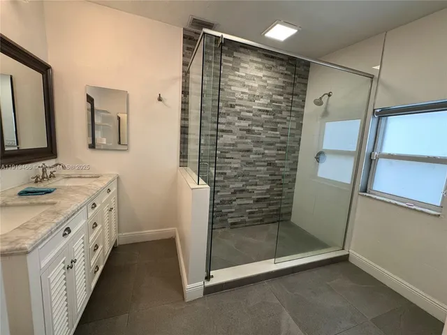 a bathroom with a shower sink and mirror