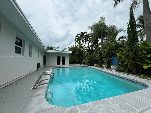 swimming pool view with a garden space