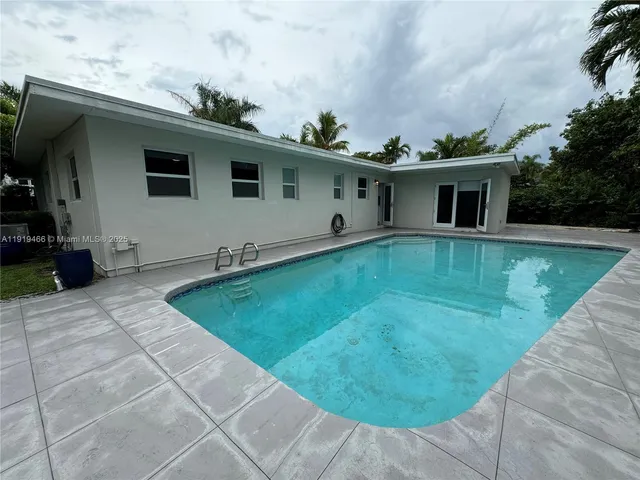 a backyard of a house with table and chairs