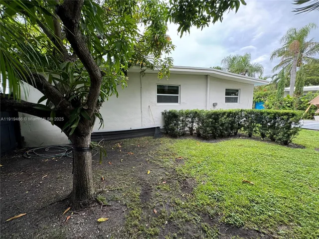 a view of backyard of house with green space