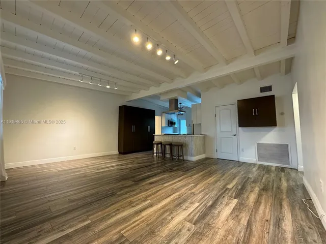 a view of a livingroom with a flat screen tv wooden floor and a ceiling fan