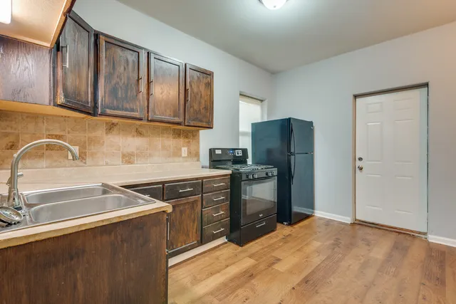 a kitchen with stainless steel appliances granite countertop a refrigerator stove and sink