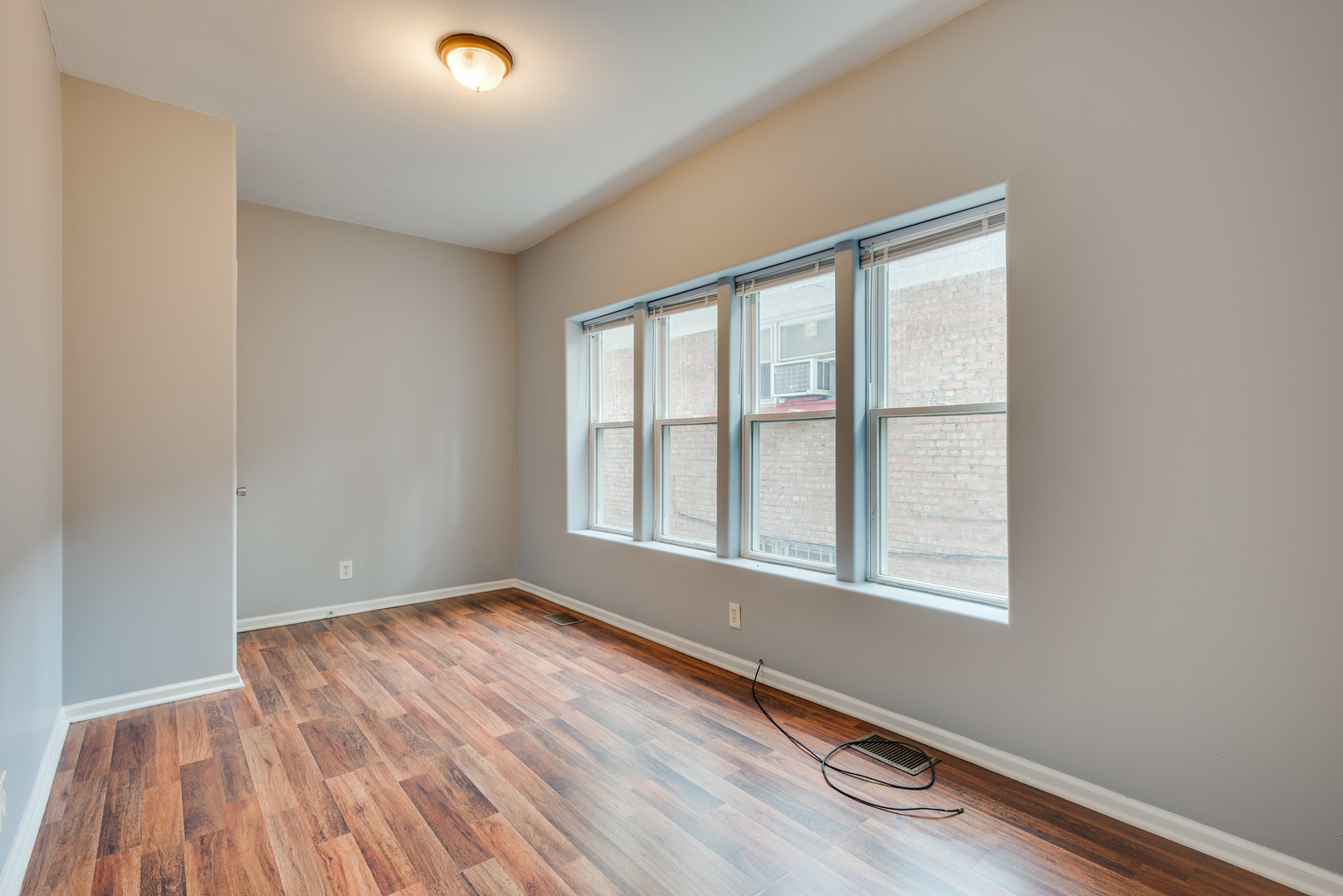 1326 East 72nd Street, Unit 1 Chicago, IL 60619 - Photo 8 of 10 an empty room with wooden floor and windows