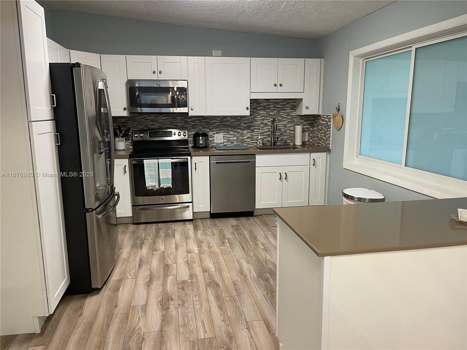 39 Lake Shore Drive Key Largo, FL 33037 - Photo 11 of 27 a kitchen with granite countertop a refrigerator stove and sink