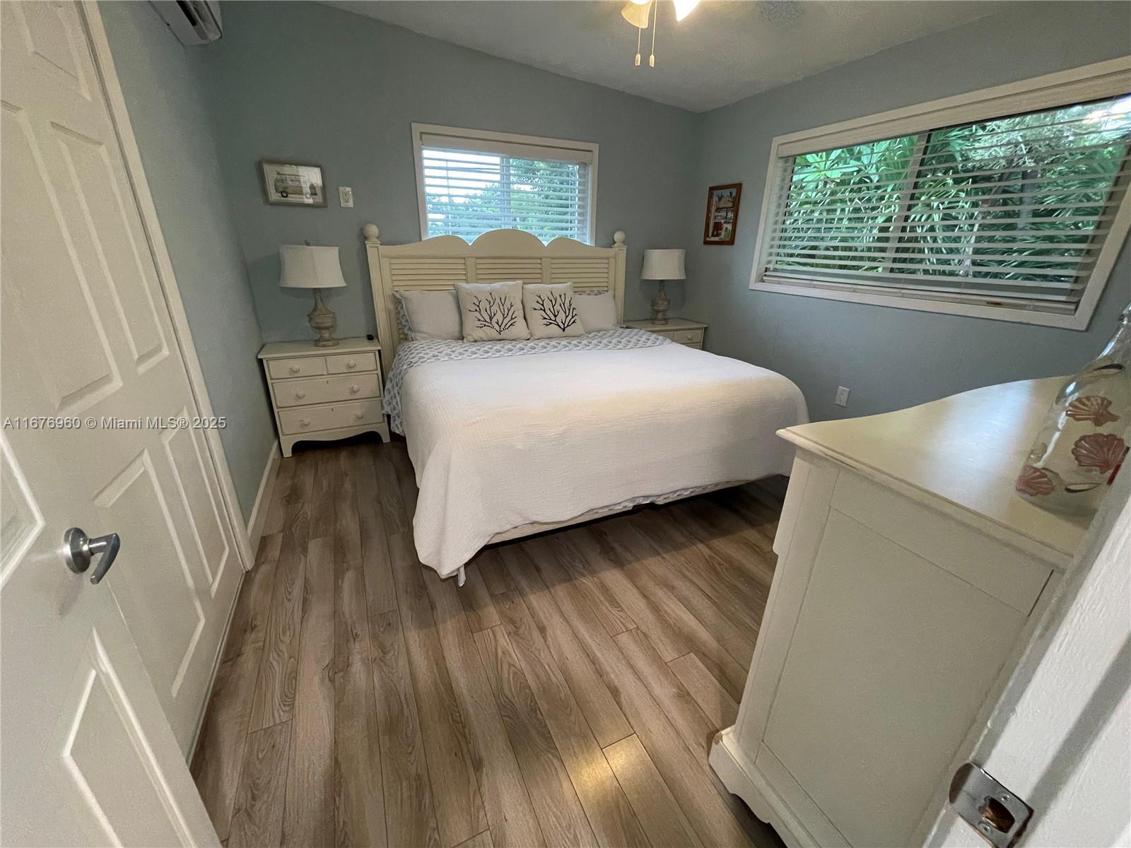 39 Lake Shore Drive Key Largo, FL 33037 - Photo 12 of 27 a bedroom with a bed and wooden floor