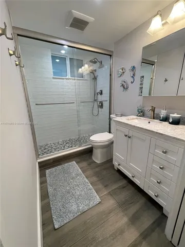 a bathroom with a sink a toilet and shower
