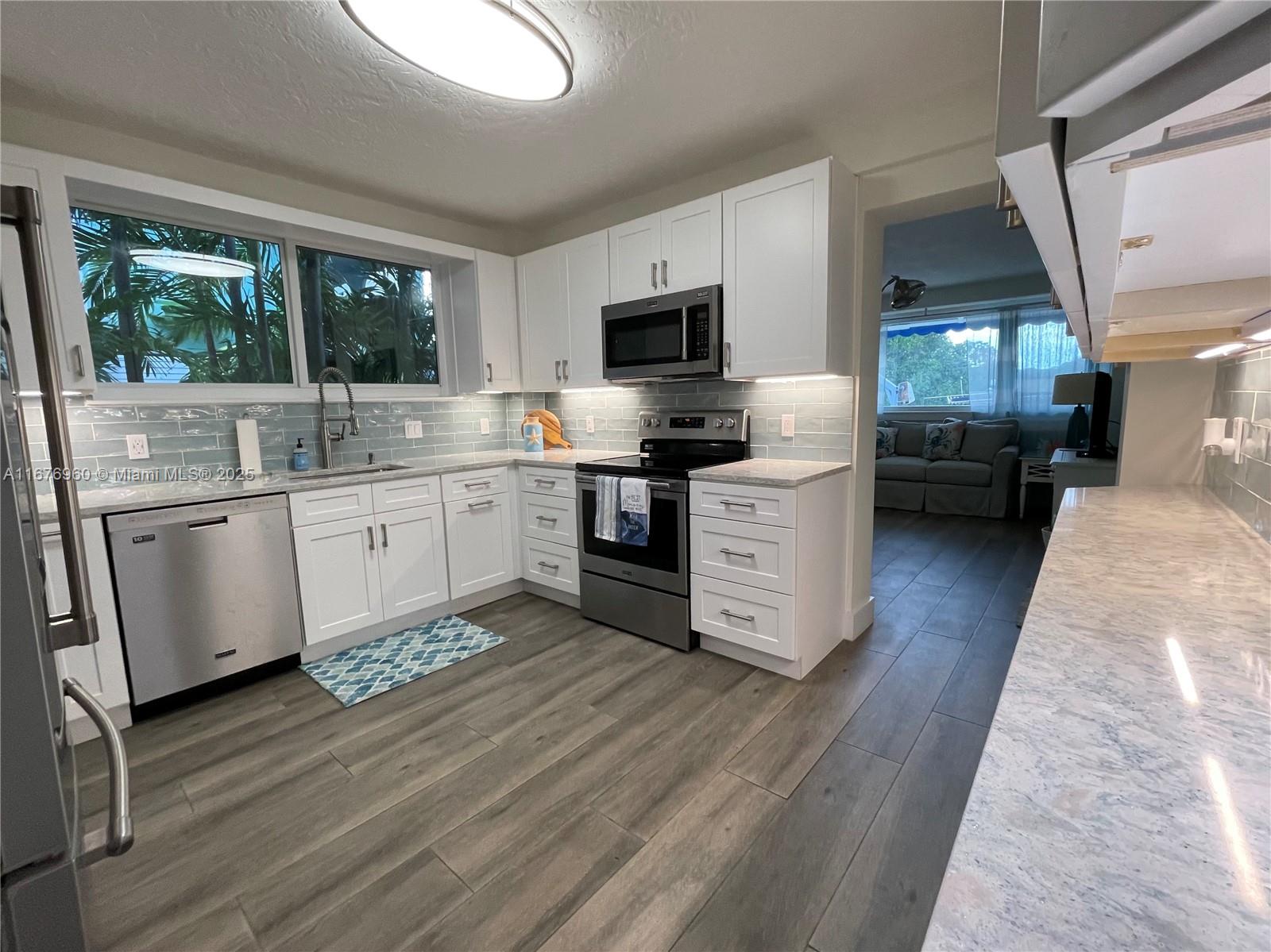 39 Lake Shore Drive Key Largo, FL 33037 - Photo 19 of 27 a kitchen with stainless steel appliances granite countertop a stove a sink and a microwave