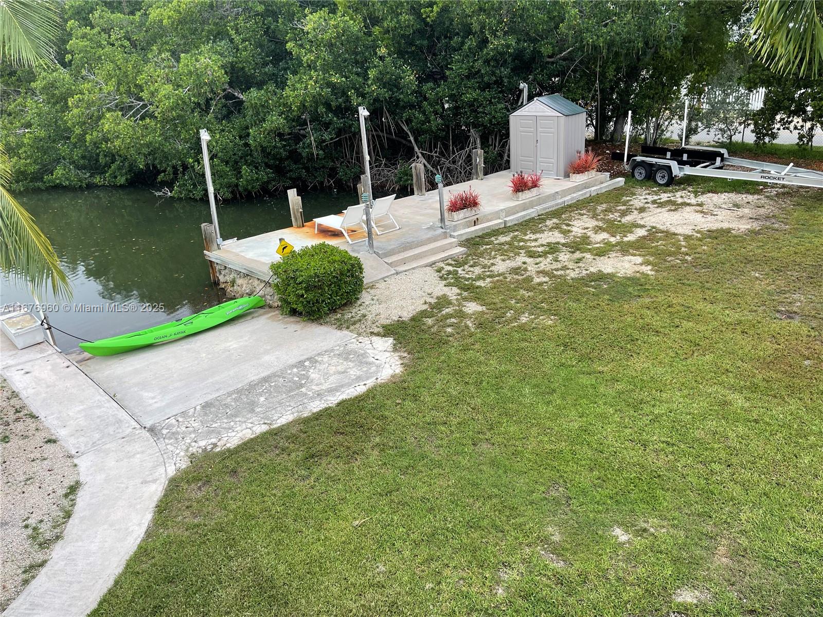 39 Lake Shore Drive Key Largo, FL 33037 - Photo 25 of 27 a backyard of a house with chairs and table