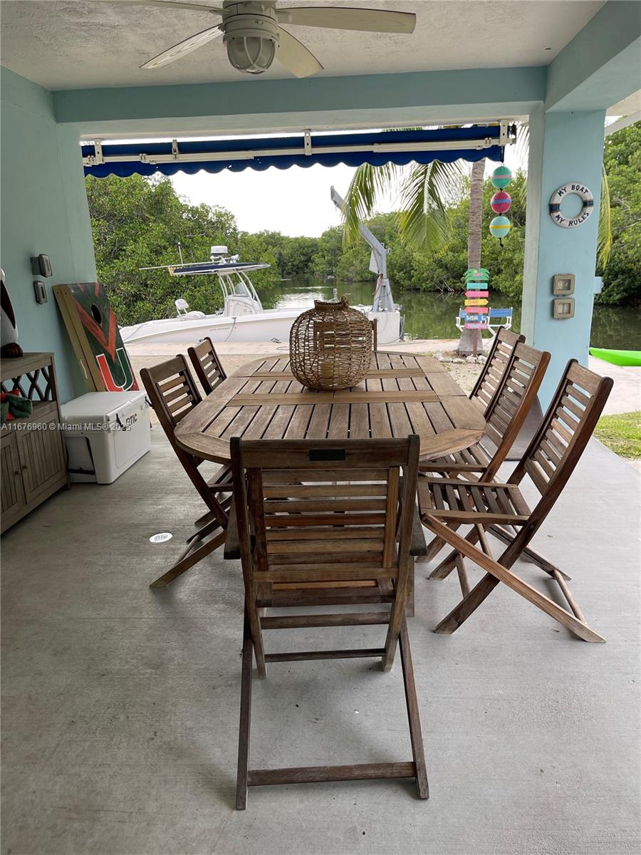 39 Lake Shore Drive Key Largo, FL 33037 - Photo 26 of 27 a view of a patio with a table chairs and a floor to ceiling window