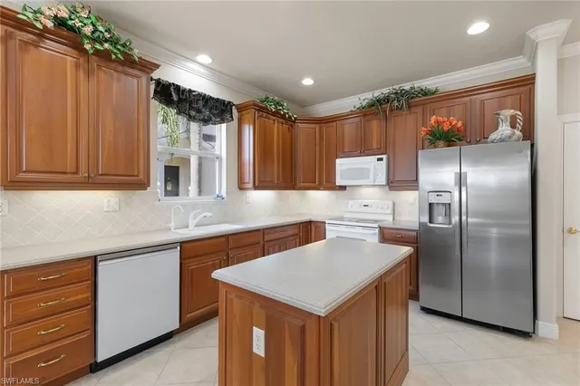 a kitchen that has a sink stainless steel appliances wooden floor and cabinets