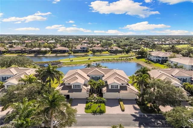 an aerial view of residential houses with outdoor space and ocean view