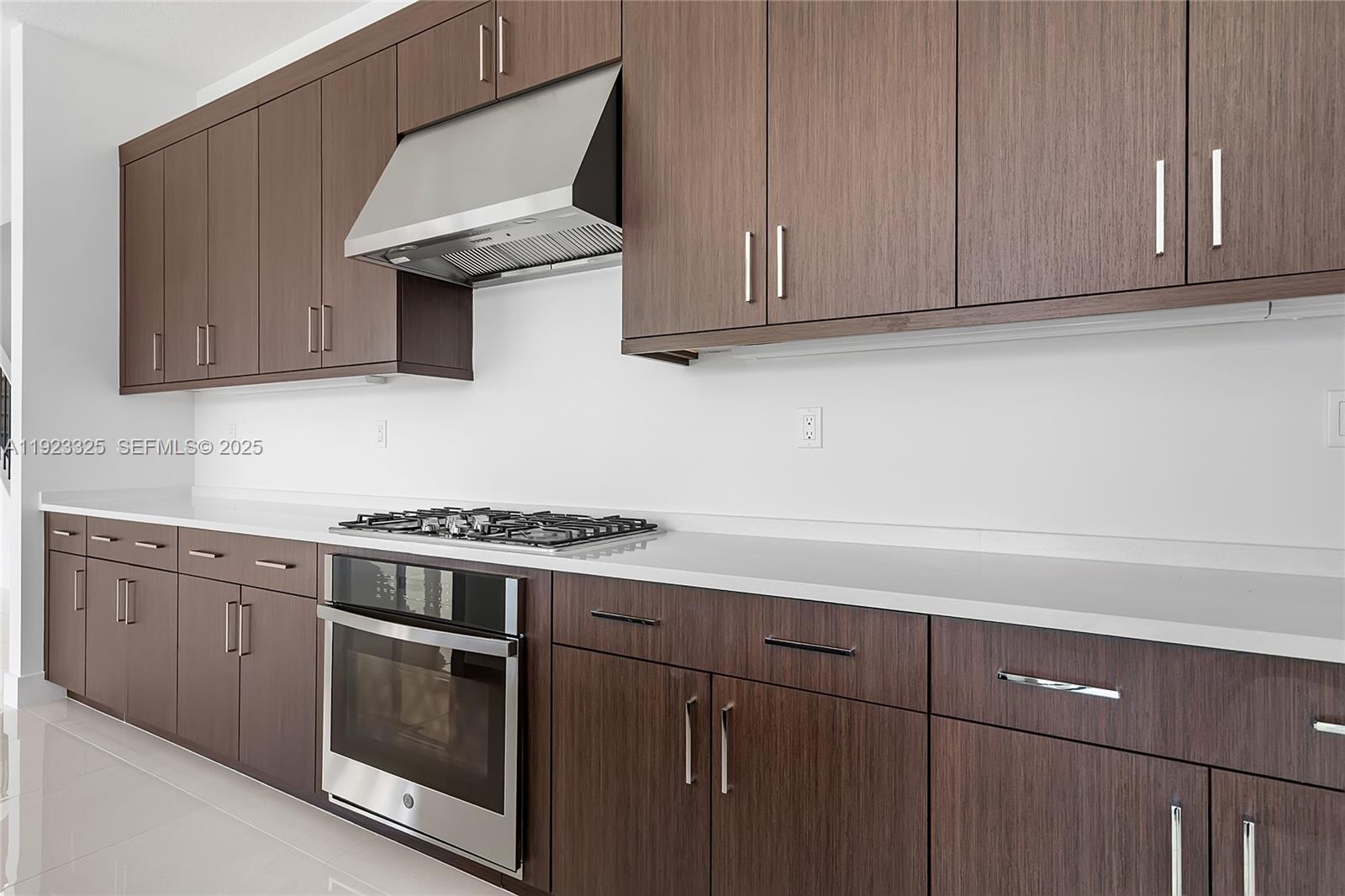 9362 Tulip Leaf Court, Unit 9362 Boca Raton, FL 33434 - Photo 7 of 80 a kitchen with stainless steel appliances wooden cabinets and a stove top oven