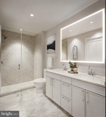 a bathroom with a double vanity sink toilet and shower