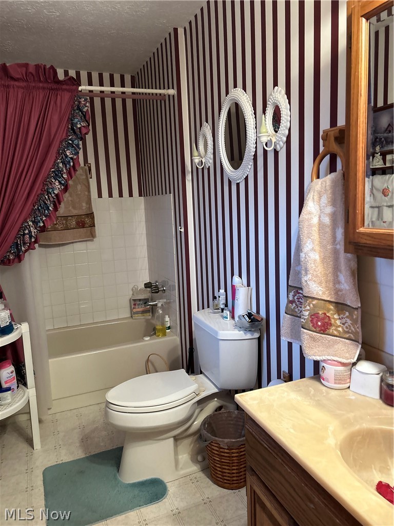 73323 Old Twenty One Road Kimbolton, OH 43749 - Photo 7 of 14 Bathroom with wallpapered walls, shower / tub combo, vanity, light floors, and a textured ceiling