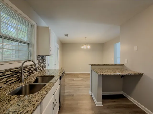 a kitchen with granite countertop a sink and a stove