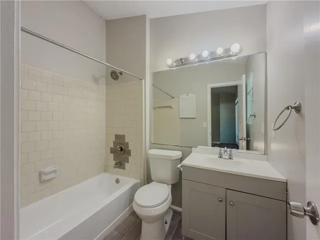 a bathroom with a sink a toilet a mirror a bathtub and shower