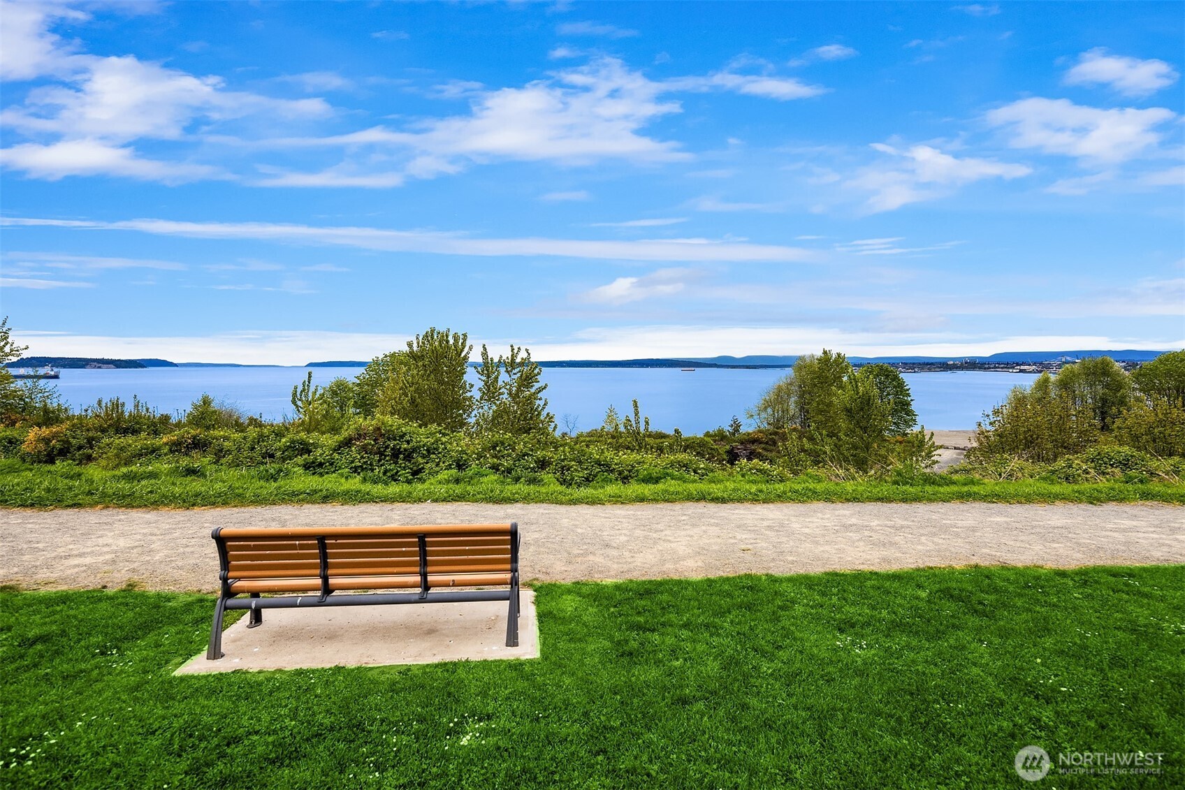 4938 Narbeck Avenue Everett, WA 98203 - Photo 38 of 40 a wooden bench sitting in the grass near a lake