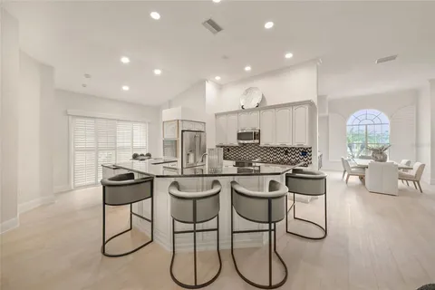 a kitchen with stainless steel appliances kitchen island granite countertop a sink and chairs