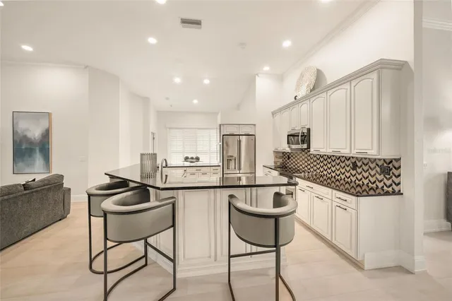 a living room with furniture a large window and a refrigerator