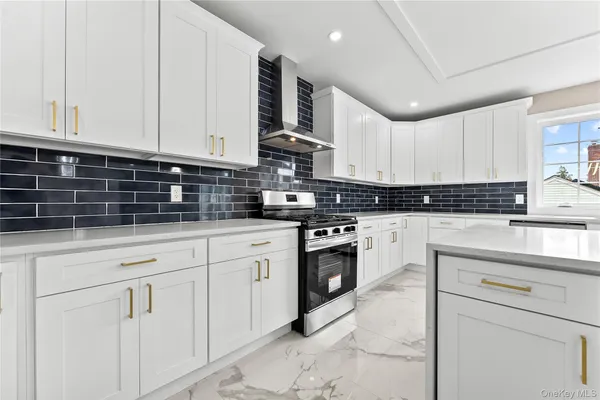 a kitchen with granite countertop white cabinets and stainless steel appliances